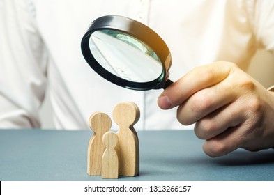 A Person Looks At Family Figures Through A Magnifying Glass. The Study Of Family Composition, Statistics. Birth Control And Juvenile Police. The Study Of Society And The Behavior. Marketing.