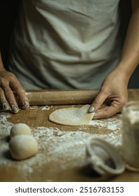 A person making beautiful handmade bao dumplings and sprinkling flour on them.