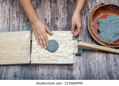 Person Making Corn Tortillas At Home With A Hand Tortilla Maker.