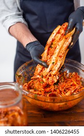 Person Making Kimchi Wearing Black Rubber Gloves For Protection