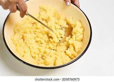 A Person Making Mashed Potatoes In A Bowl