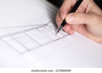 Person making a technical drawing of architecture, holding a mechanical pencil over the work table. - Shutterstock ID 2170084989