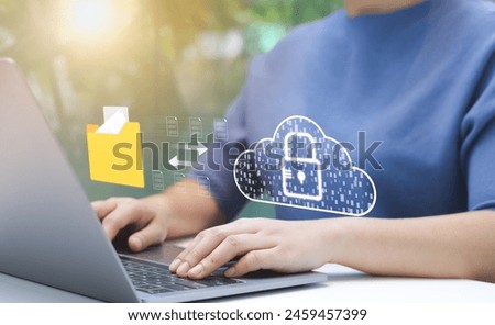Person Managing Secure Cloud Data Transfer. An individual uses laptop to manage secure data transfer to cloud, virtual lock, representing robust cybersecurity measures. File storage, Manage folders,