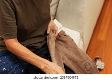 person meticulously folding and ironing fresh laundry in a neatly organized, sunlit home, showcasing household perfection - Powered by Shutterstock