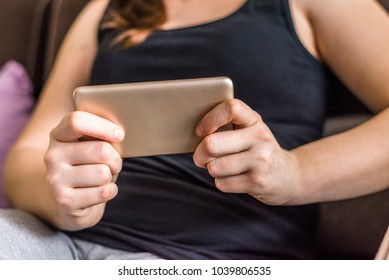 Person With Mobile Phone, Playing Games Or Watching Movie On The Smartphone, Relax And Cozy Moment On Sofa At Home