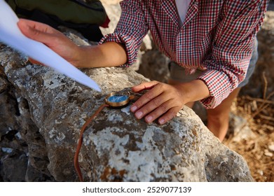 A person navigating with a compass and map on a rocky surface, embodying exploration and adventure. The scene evokes a sense of direction and outdoor discovery in daylight.
