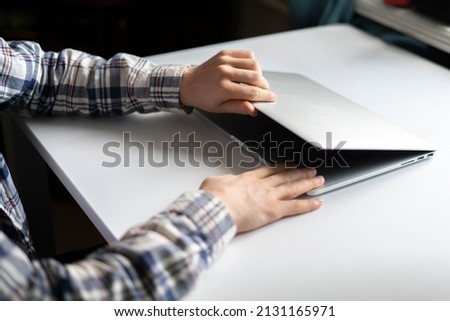 person opens laptop computer to do some online work on project