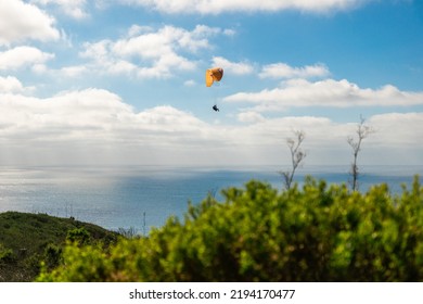 A Person Paragliding In Clear Sky Above The Pacific Ocean In Southern California Coast