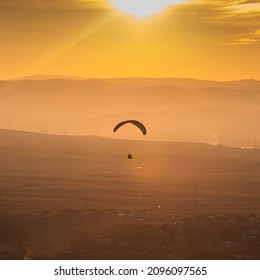 A Person Parasailing At The Golden Hour