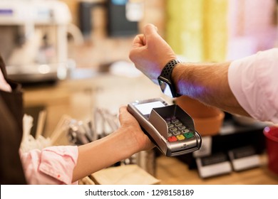 Person paying at cafe with smart watch wirelessly on POS terminal - Powered by Shutterstock