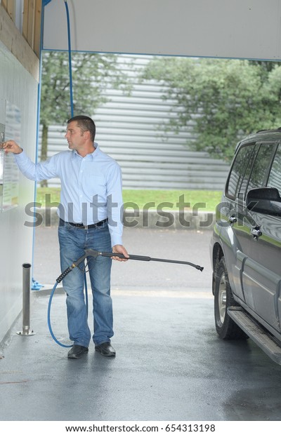 person paying coins to self service automatic car
cleaning machine
