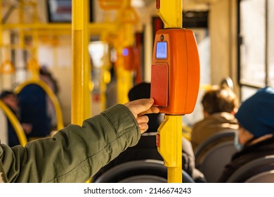 a person pays for public transport with a plastic card by attaching the card to an electronic reader. contactless fare payment technology in public transport. - Shutterstock ID 2146674243