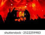 A person photographing with a mobile phone at a concert 