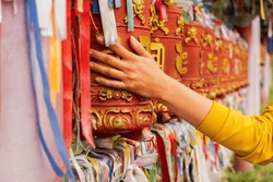 Person Pilgrim Female Hand Touching Turning Spinning Buddhist Prayer Wheel At Buddhist Monastery. Prayer Wheels In Buddhist Stupa Temple. Buddhism Religion Concept