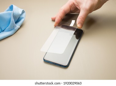 A Person Places A Protective Glass Or Film On A Smartphone. Copy Space.