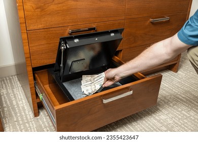 Person placing valuables in hotel room safe