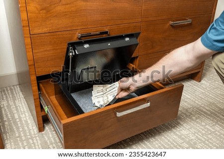 Person placing valuables in hotel room safe