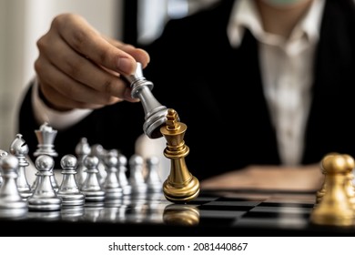 Person playing chess board game, conceptual image of businesswoman holding chess pieces against opponent chess against business competition, planning business strategies to defeat business competitors