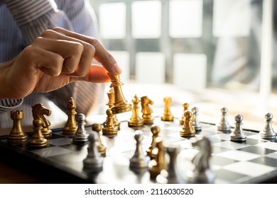 Person Playing Chess Board Game, Business Man Concept Image Holding Chess Pieces Like Business Competition And Risk Management, Planning Business Strategies To Defeat Business Competitors.