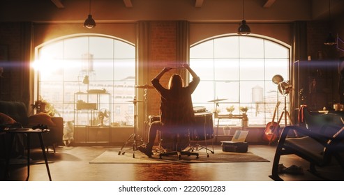 Person Playing Drums During A Band Rehearsal In A Loft Studio With Sunlight At Daytime. Drummer Practising Alone Before A Live Concert On Stage. Warm Color Editing.