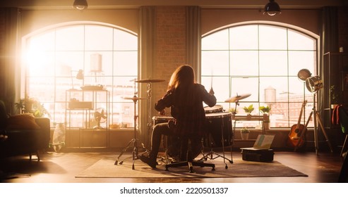 Person Playing Drums During A Band Rehearsal In A Loft Studio With Sunlight At Daytime. Drummer Practising Alone Before A Live Concert On Stage With Audience. Warm Color Editing.