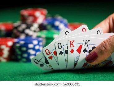 Person playing poker and looking at cards