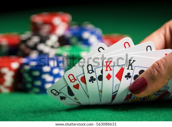 Person playing poker\
and looking at cards