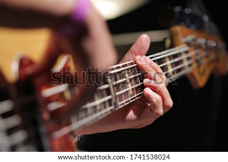 
person playing yellow electric bass