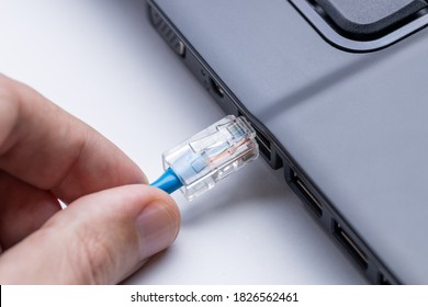 person plugging internet ethernet cable to laptop pc. online and network access conceptual. internet connection problem conceptual.