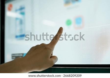 A Person Pointing at Touchscreen Interface with App Icons