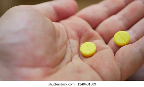 Person Pouring Bunch Of Prescription Yellow Opiate Pills Into Hand