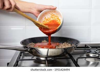 The Person Pouring Tomato Sauce Over Beef. Preparation Of An Italian Dish.