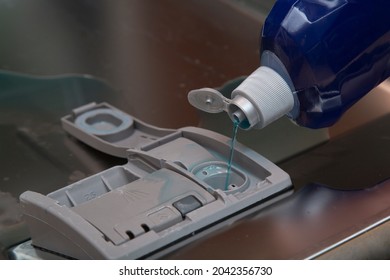 A Person Pours A Rinse Aid Into The Dishwasher.