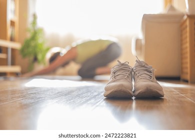 Person Practicing Yoga In Child Pose At Home.
Focus on yoga shoes with a person doing child's pose in the background at home. - Powered by Shutterstock