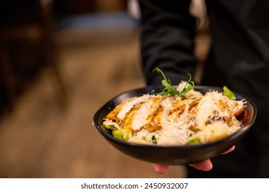 Person presenting a bowl of vibrant grilled chicken salad, emphasizing the appeal of fresh, healthy cuisine - Powered by Shutterstock