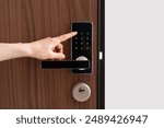 Person presses a button, enter pass code on digital lock with keypad. Digital technology, keyless system in hotel, privacy and security concepts