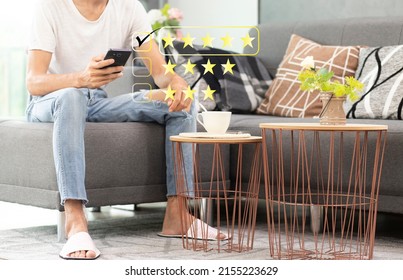 Person Pressing On Smartphone With Five Stars Icon For Feedback Review Satisfaction Service During Sitting On Sofa At Home, Online Review Concept