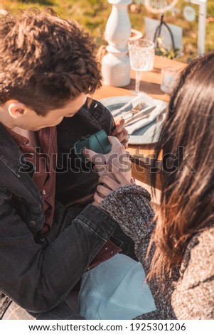 A Person Pulling out a ring box to propose to their lover at a luxury picnic outdoors