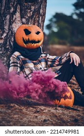 Person With Pumpkin For Head And Smoke Bomb. High Quality Photo