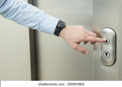 Person Pushing Up Arrow Elevator Button.