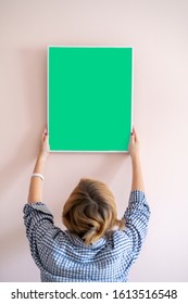 Person Put The Empty Frame For Family Photo On The Wall At Home In The Room On The Wall, Simple Mock Up Design