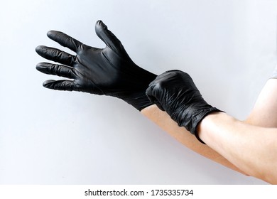 person put on black latex gloves on white background - Shutterstock ID 1735335734