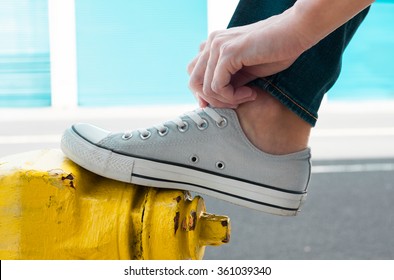 Person Putting On Pair Of Shoes. (Fashion Concept)