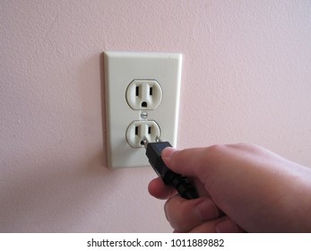 Person Putting Plug Into American Wall Outlet 