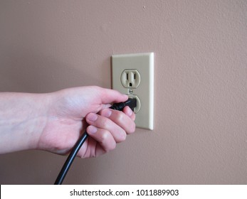 Person Putting Plug Into American Wall Outlet 