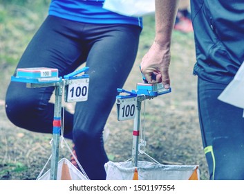 Person Racing To An Orienteering Check Point, Put The Finger Chip Into Digital Check Box.  Outdoor Orienteering Check Point Activity.