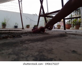 A Person Reaching Down To Clear Debris And Dirt On The Pavement In The Garden - Image Of Doing Odd Jobs, Maintenance Concept, Cleaning Time.