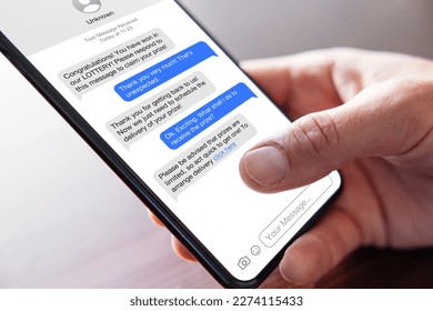 Person reading scam messages on mobile phone - Shutterstock ID 2274115433