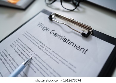 Person Reading Wage Garnishment Documents At Desk