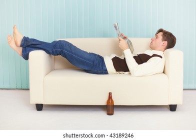 The person reads magazine comfortably lying on a sofa - Powered by Shutterstock